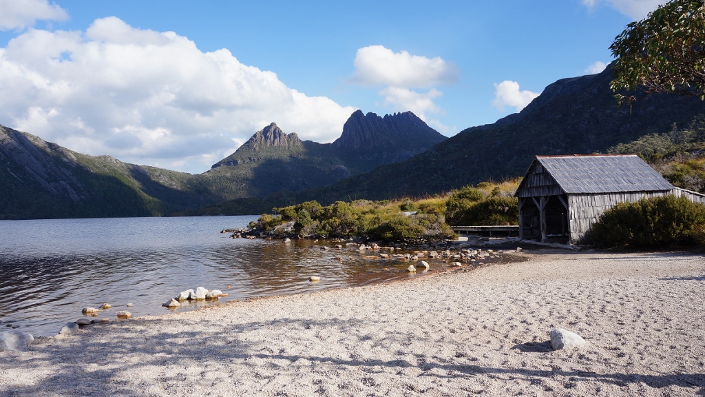 從鴿子湖畔仰望冰川岩及湖邊的老舊船屋。