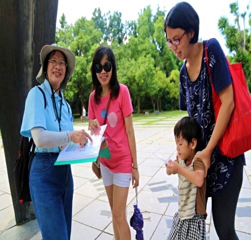 跟遊客介紹金高都的精神象徵—金雞日晷