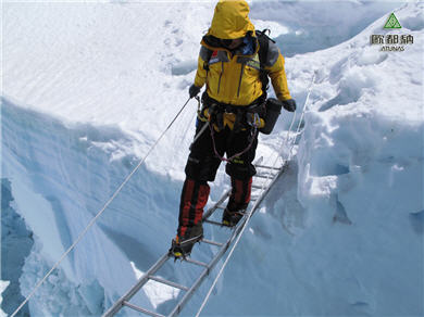 昆布冰河上搭著簡易鋁梯，穿著冰爪的隊員得十分小心地通過深不見底的冰河裂隙，相當驚險。