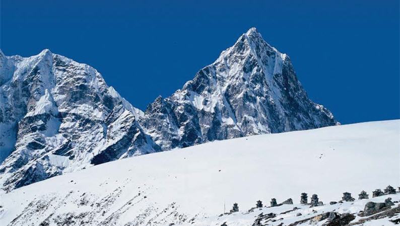 攝於聖母峰的基地營,遠處石堆為紀念登山罹難者所立。