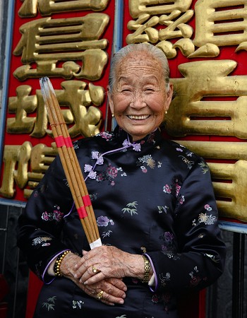 年近百歲的老婦人站在浯島城隍廟執事牌前，虔誠等待一年一度的廟會開鑼 林金榮攝