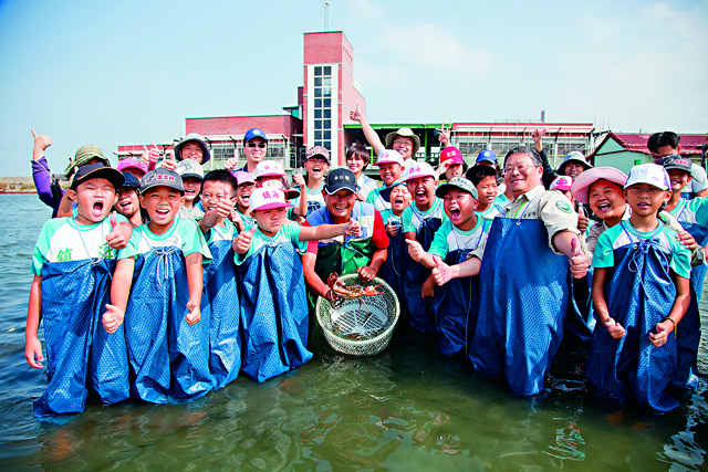 05-野外教室7_穿著青蛙裝，雙腳踏入魚塭，感受濕地的溫暖和柔軟，學生有了一個難忘的環境體驗。