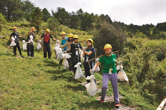 挑扁擔搬運石頭修復步道。