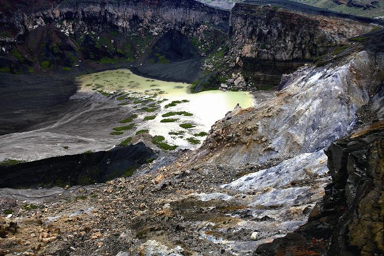 阿蘇中岳火山口下方的湖水因岩石中銅、鐵等物質溶出而淡綠色澤/斯斯攝