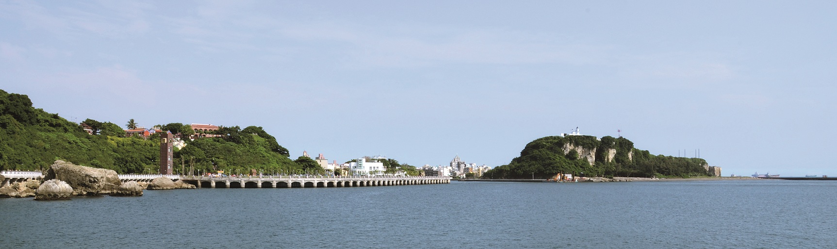 由西子灣海堤遠眺位於哨船頭山丘上的打狗英國領事館官邸,以及位於旗後山上的旗後燈塔/壽籌處提供
