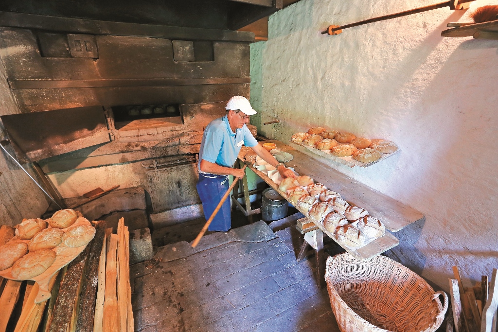 麵包師傅正用傳統的窯及工具製作手工麵包