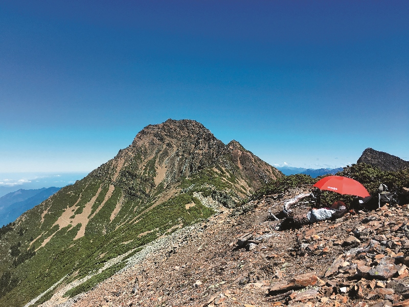 玉山南稜碎石坡,在夏日白天酷熱難耐,拍攝團隊 苦無遮陽之處;但卻在夜晚驟變為寒風凍骨的狀態