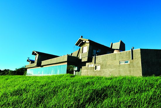 A-01 東立面：建築立面面對龍鑾潭，由潭面方向看過來，中心為一層樓，掩於低丘地形之中還有一層樓