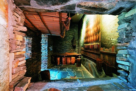 石板屋內部陳設，包括床以及漁具，並運用畫牆做空間的延伸以及其他生活用具的呈現