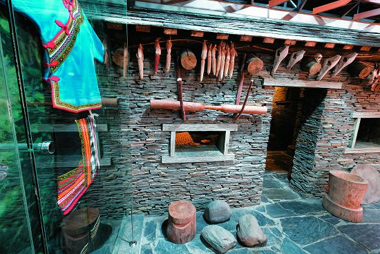 石板屋外部陳設，除了獨立展示的布農族傳統服飾外，還有穀類、動物骨骼以及杵臼等其他生活用具