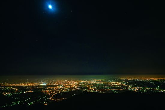 陽明山國家公園大屯山拍攝夜景，光線經由空氣中懸浮微粒的散射，讓城市彷彿壟罩在光罩中的天空輝光現象／楊懷智攝