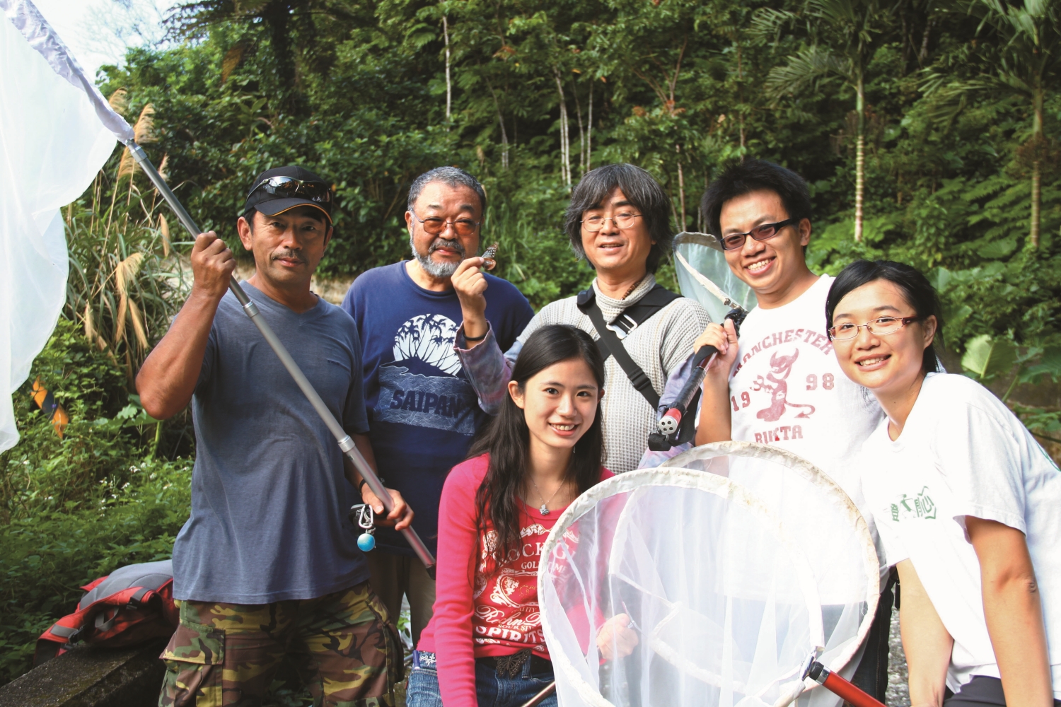 陳建志(後排中)率領的臺灣團隊與日本研究人員捕獲有日本標幟的青斑蝶/陳建志 提供