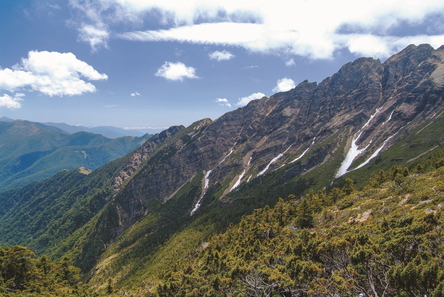 左方尾端最低山頭為鹿山,從右方三叉峰開始海拔急降近一千公尺,回程上坡,挑戰極為艱難,名列岳界四大鳥山之一/何昌穎 攝