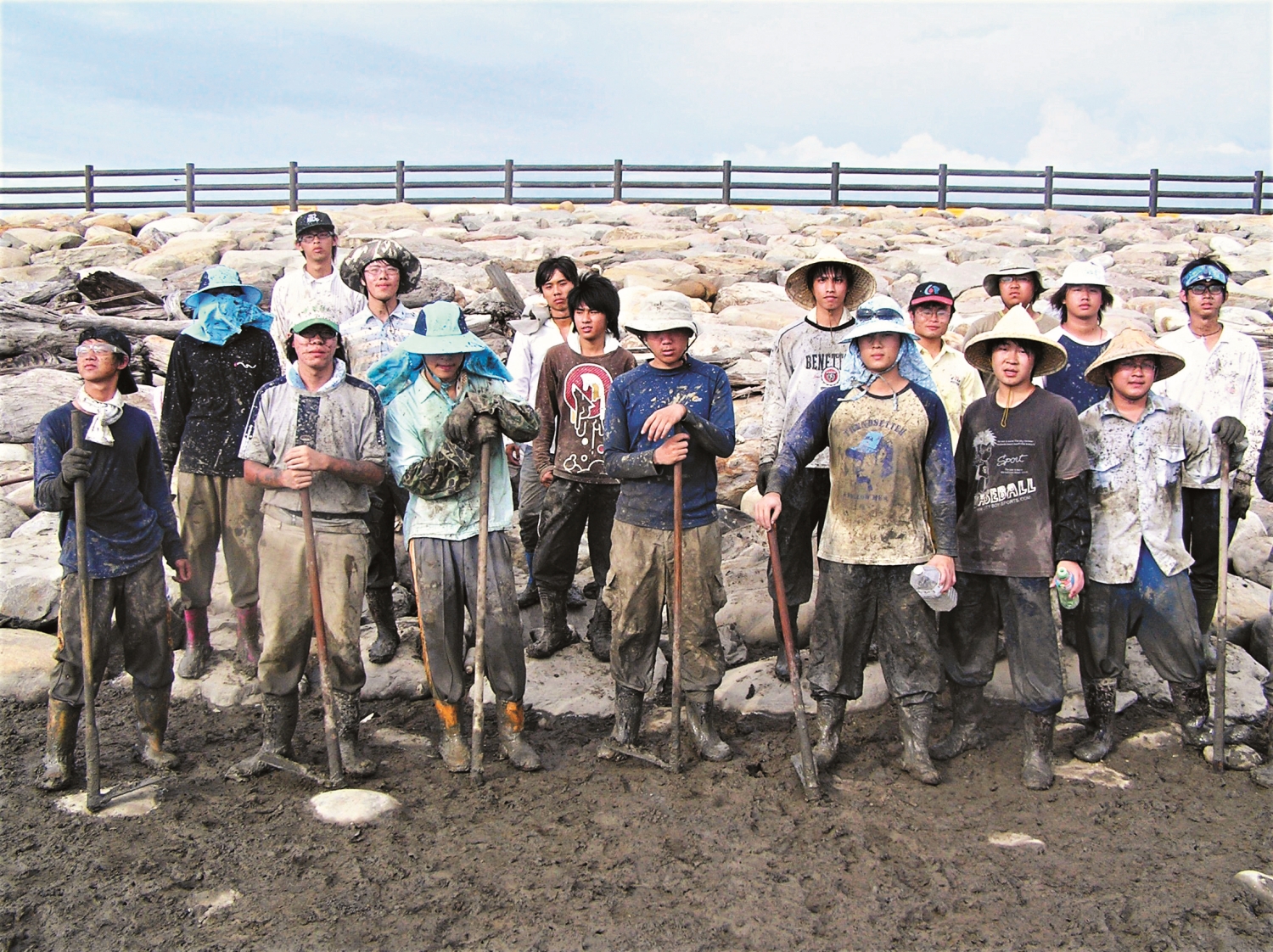 在疏伐紅樹林後，滿身泥濘的雇工們一起留影／張登凱 提供
