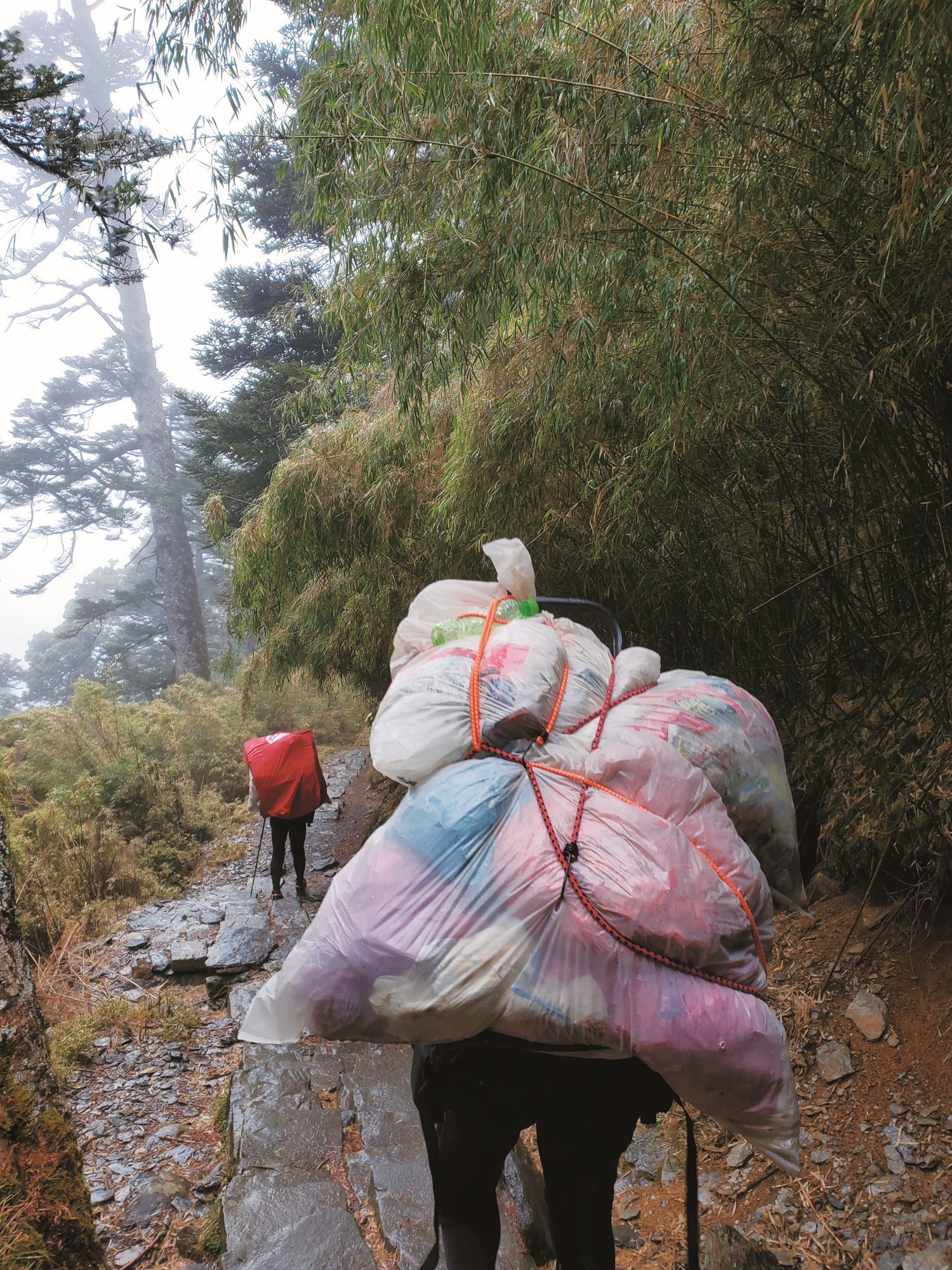 不論是食材運補或廚餘垃圾下山皆須依靠人力背負／玉管處 提供