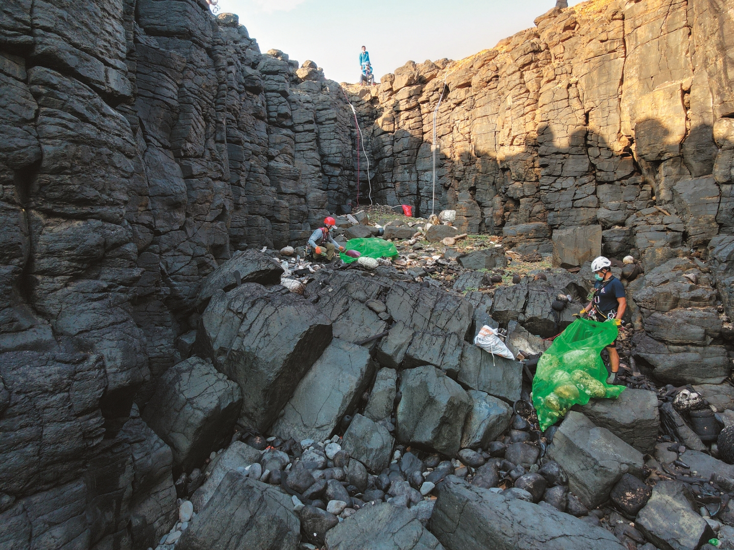 在高低落差變化劇烈的玄武岩地形間撿拾海漂垃圾／陳祈濬 提供