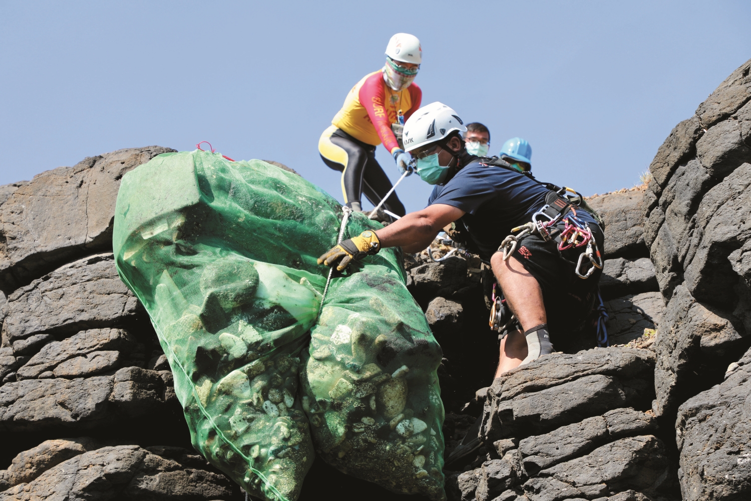 特戰志工在西吉嶼海蝕崖運用吊掛方式進行搬運／吳明翰 攝