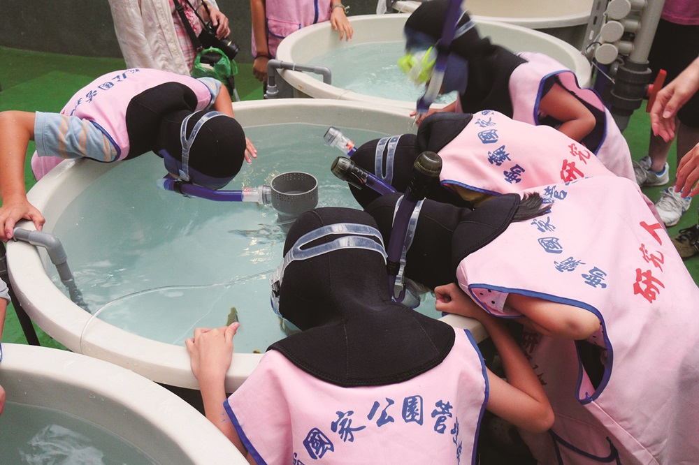 Children experiencing counting fish in the tank /Photos provided by Shei-Pa National Park Headquarters