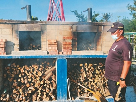 建造窯烤爐將移除後的銀合歡枝幹燃燒，作為窯烤披薩的燃料／海管處東沙管理站 提供