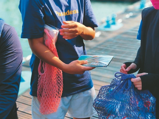 旅客協助將空瓶罐攜離東吉嶼，於碼頭兌換海管處宣導品／海管處提供