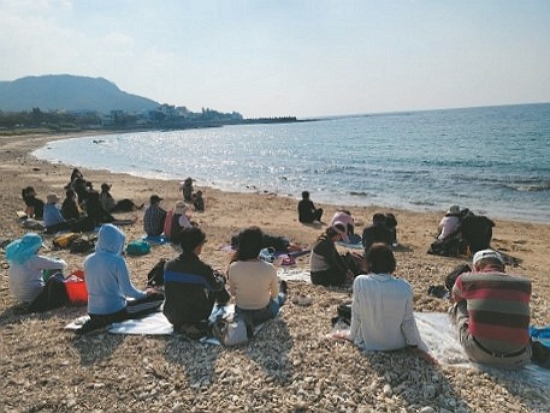 在沙灘上席地而坐，放空享受與自然融為一體的時刻／墾管處提供