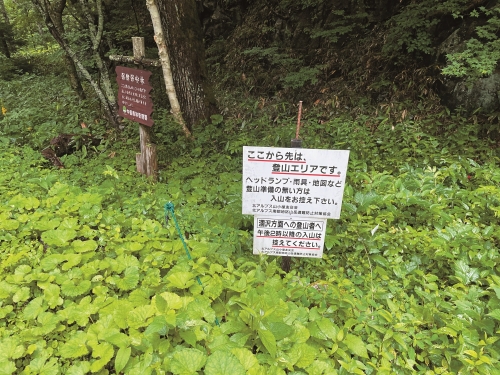 十分簡易的登山口牌示：「你將進入山區，沒有頭燈、雨具、地圖等，請勿入山。」