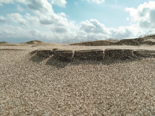 俯身觀察，可以看見砂石被落山風吹拂飛濺的狀態