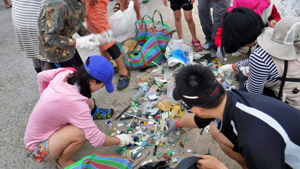 淨灘後，眾人合力將垃圾分類，分辨可以再資源回收再利用的物品種類(墾丁國家公園管理處提供)
