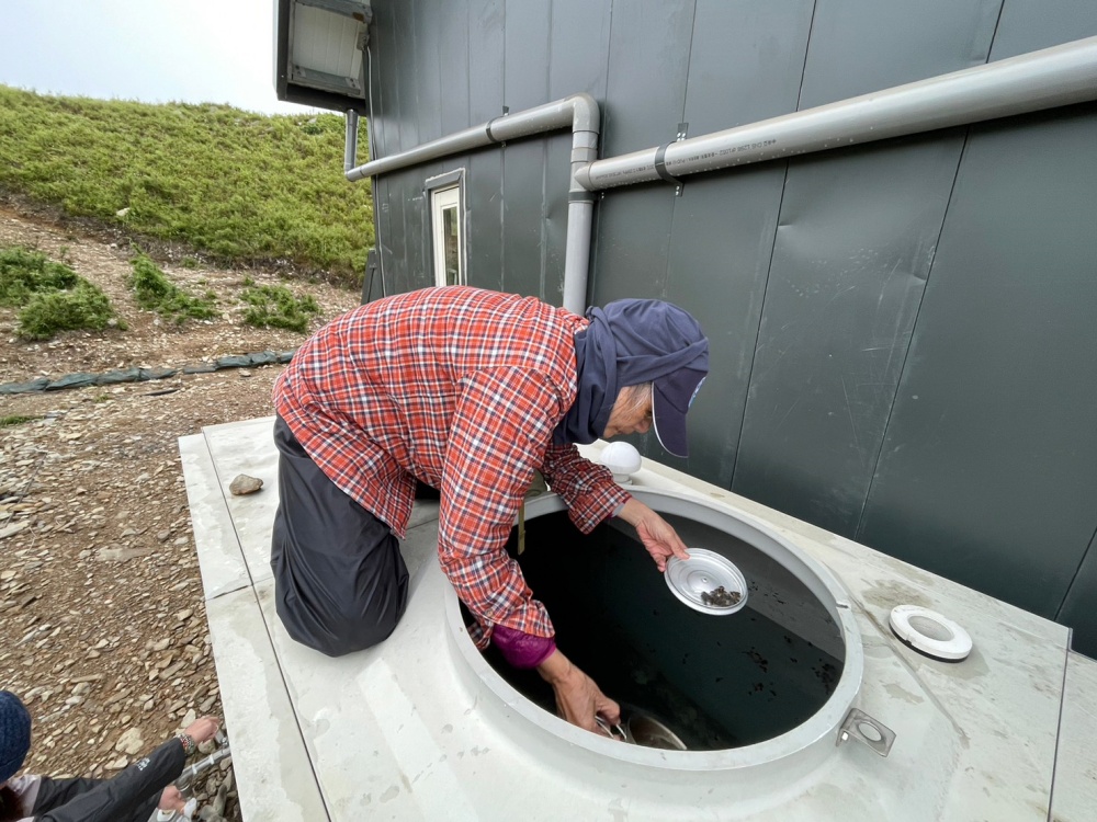 保育志工進行勤務，檢視油婆蘭山屋集水桶，並予以清理乾淨(保育志工鄭朝雄提供)