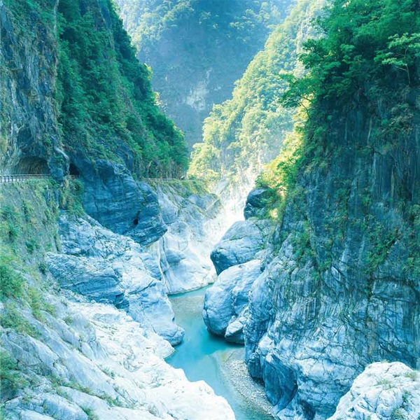 山壁巍峨險峻，鑿壁修築的公路宛若鬼斧神工，山壁上的植被新綠，生意盎然。攝於太魯閣國家公園九曲洞。