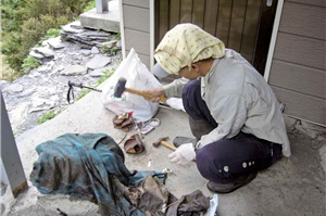 在八通關的白洋金礦山屋前處理垃垃圾。避免傷及清潔人員，使用鐵槌將碎塊垃圾再仔細敲碎，用意在於壓縮垃圾的收集量，以減低負重壓力/賴光亮提供