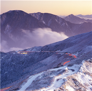 雪季時，上山賞雪的遊客絡繹不絕，以慢速快門捕捉公路上熙來攘往的車輛與靄靄白雪形成對比，煞是有趣。(攝於太魯閣國家公園)