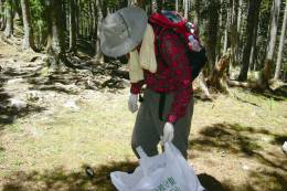 Shei-pa volunteers pack out trash in trash bags with conservation slogans printed on them
