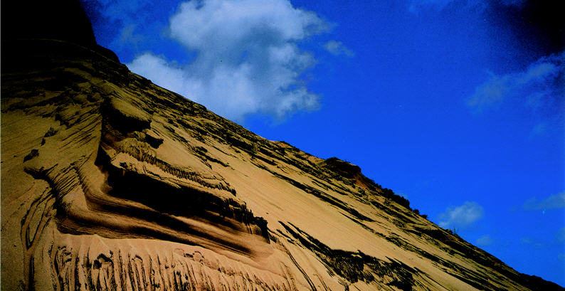 Viewed from down under, the sand cascade at Fongchueisha looks no longer like a smooth river but more like an imposing god guarding the clouds and sky up above.