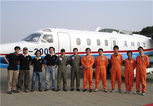 The DOTSTAR team (dressed in orange) posed for a photograph with AIDC aircraft staff.