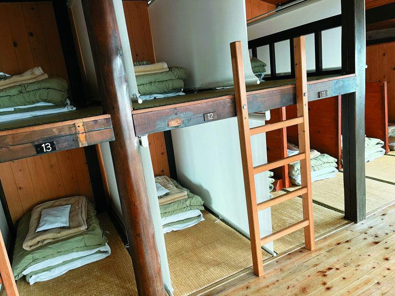 通鋪床位用布簾隔離強調隱私，整潔舒適