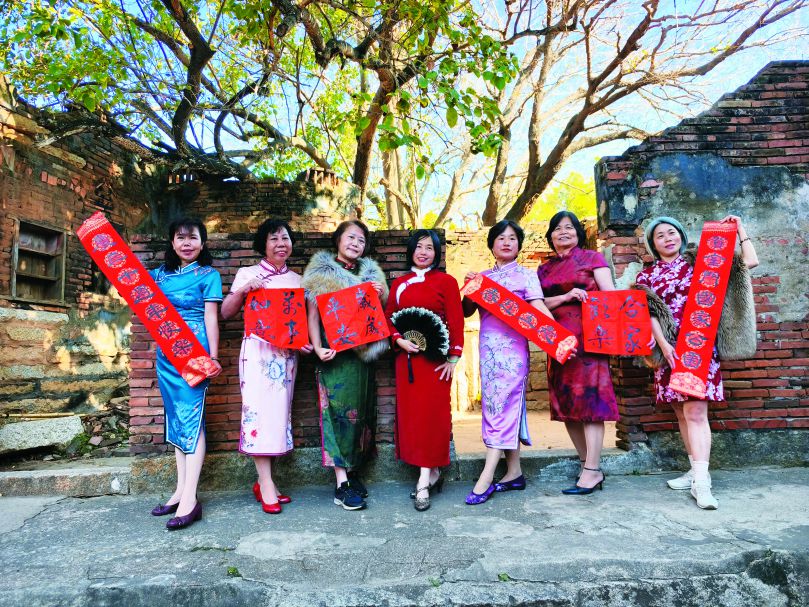 2025年農曆春節前夕，孫麗婷（中）與志工穿著旗袍拍攝金管處臉書粉絲專頁賀歲照