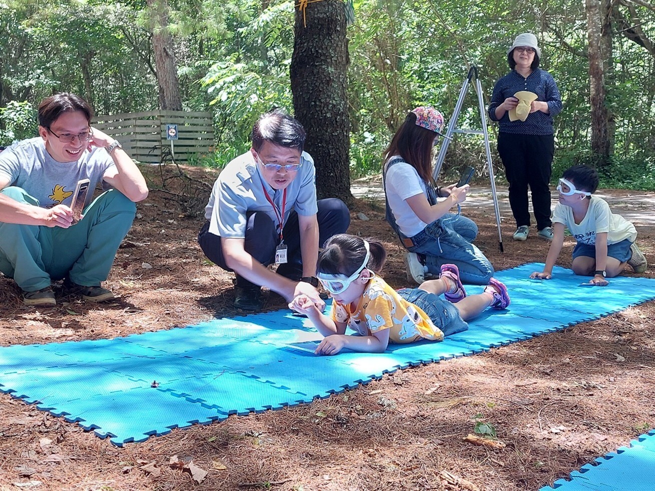 Scene of children wearing goggles and pretending lying prone on the river to count fish