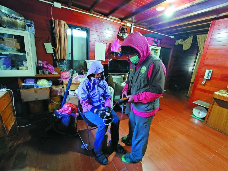 管理員協助身體不適山友測血含氧量及心跳／何小綠 攝